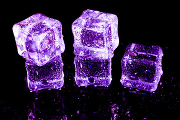 Purple ice cubes on a black table.