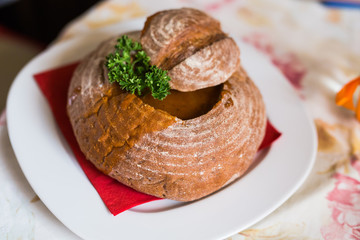 Goulash soup with beef, potato and meat sausage, served in a bread bowl
