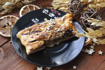 Strudel puff pastry with apple and chocolate on a black plate. Rustic style.