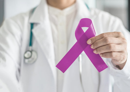 Lavender purple cancer (all kinds) awareness ribbon on doctor's hand support for national cancer survivor month campaign