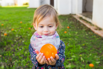 Happy laughing child playing with orange