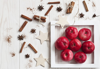 Red apples on  white wooden background. Concept for  Christmas decor, postcards, menus, invitations. Background, top view.