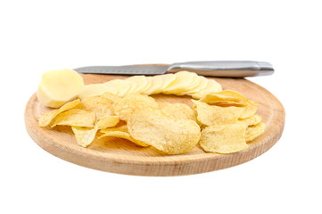 Cutting board with raw potato, potato chips and knife isolated on white background.