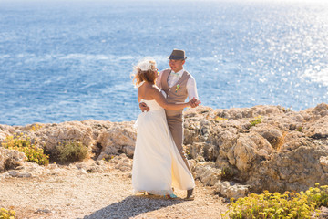 Fototapeta na wymiar Bride and groom by the sea on their wedding day.