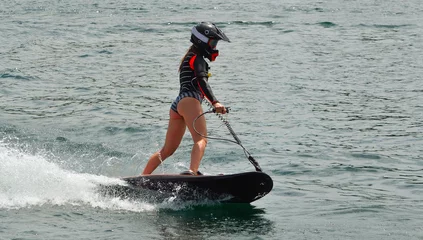 Lichtdoorlatende gordijnen Watersport Vrouwelijke Motosurf-concurrent die zich met snelheid beweegt.