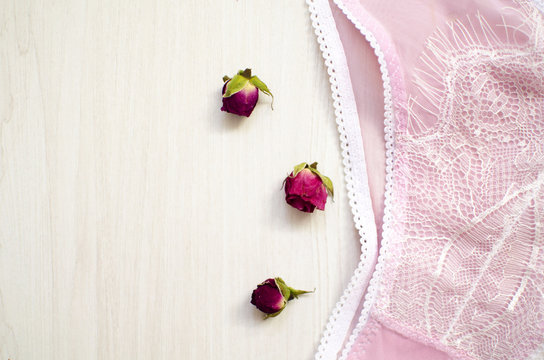 Female beauty underwear on the white wooden background. Fashion lace lingerie with dried roses and women accessories