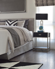 Modern classic style bedding with black shade lamp and graphic rug on the floor