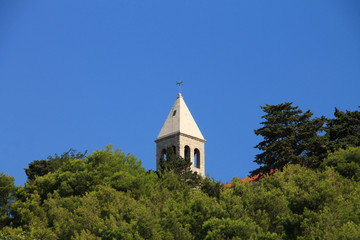 Church tower in pine tree near Brela , Croatia