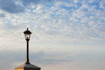 Lantern on an iron pillar against a cloudy sky background