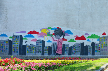 The old wall, painted in color graffiti drawing with aerosol paints. Picture of a little girl who...