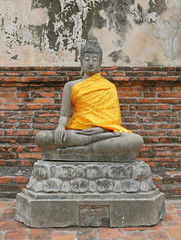 Statue of Buddha, wearing in yellow sacred fabric clothing called the robe of Buddhist Monk.