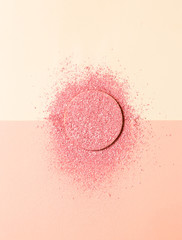 Powdered blush on a sponge on double background of pink and beige