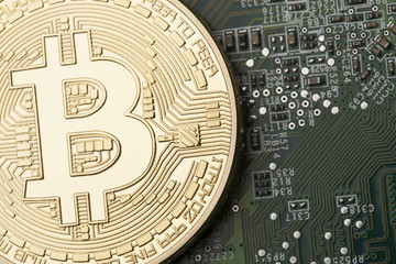 Golden Bitcoin virtual currency on a circuit board background