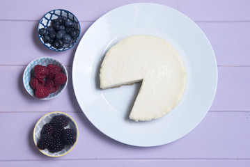 Vanilla cheesecake surrounded with blueberries, blackberries and raspberries