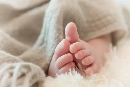 newborn baby feet on soft fabric