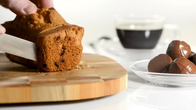 Male hands cut cake with raisin on a chopping board a sharp knife