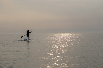 Fototapeta na wymiar Stand Up Paddling ( SUP ) auf der Ostsee im Sonnenuntergang