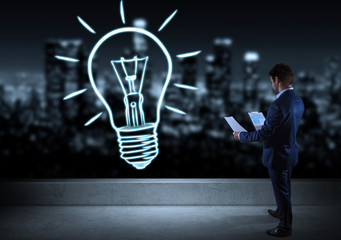 Businessman watching hand drawn lightbulb on a rooftop 3D rendering