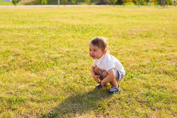 Portrait of cute little baby boy having fun outside. Smiling happy child playing outdoors