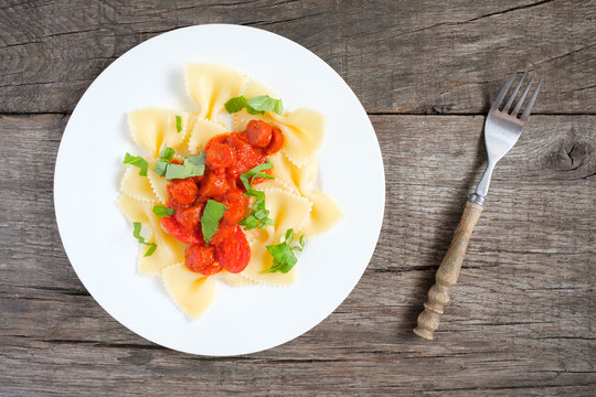 Pasta Farfalloni mit Tomatensauce, Wurst und Basilikum