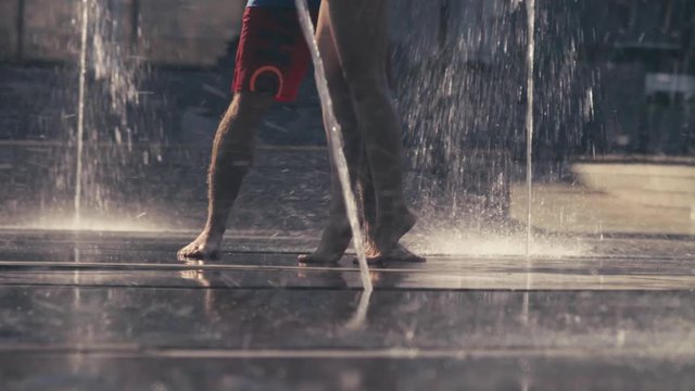 Legs of young couple dancing in the fountain