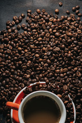
Hot coffee in red cup and coffee beans are the background.