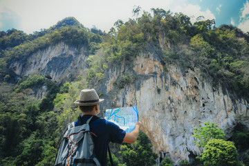 Travel man looking on map at beautiful landscape in Thailand.