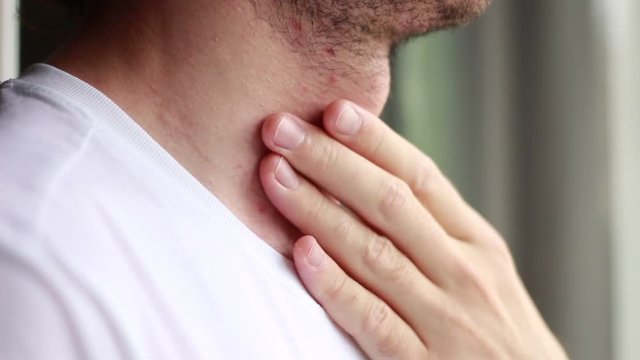 Man touching his neck near the thyroid