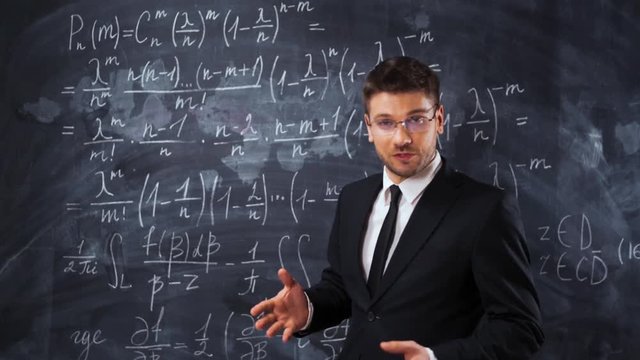 Young handsome male teacher or student in spectacles explaining decision of hard math equation. He prove the theorem and want to invite You to study in university. 4k UHD