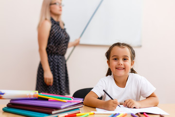 The little girl is studying. School kids work at lesson. the teacher explains