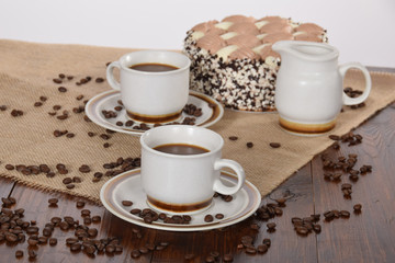 cups of coffee and milk and roasted coffee beans and cake