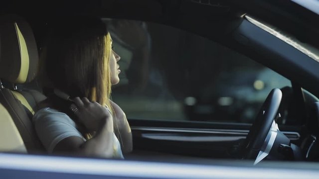 Luxury woman listen music with headphones in her comfortable car, slowmotion