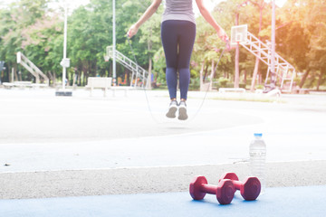 Attractive woman jumping with rope outdoor in the park, Healthy and wellness, Selective focus in...
