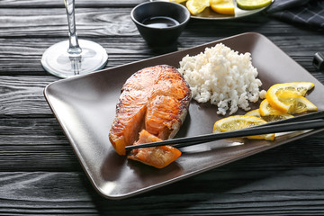 Delicious roasted salmon steak with rice on plate
