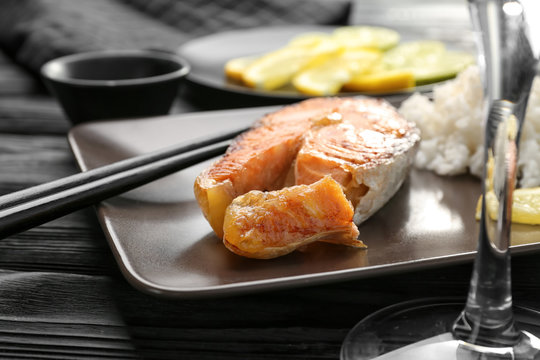 Delicious roasted salmon steak with rice on plate, closeup