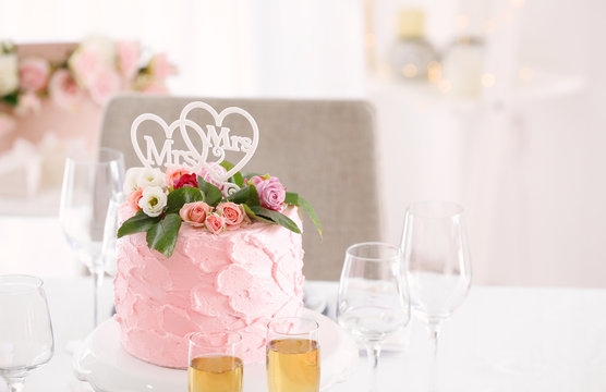 Delicious cake with decor for lesbian wedding on table