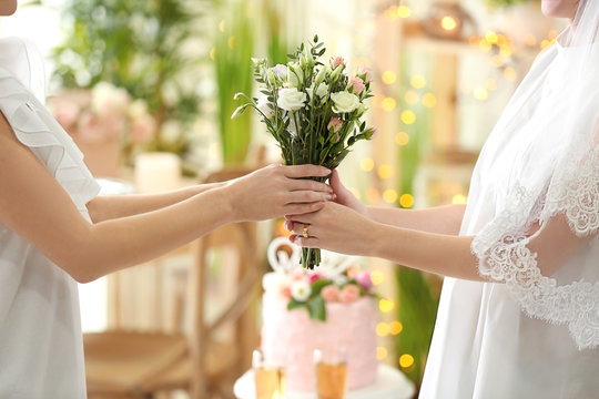 Happy brides holding bouquet of beautiful flowers on lesbian wedding