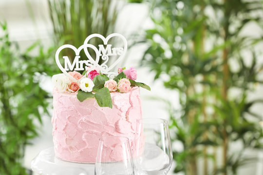 Delicious cake decorated with flowers and hearts for lesbian wedding