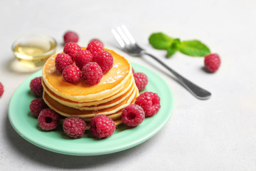 Plate with delicious pancakes on table