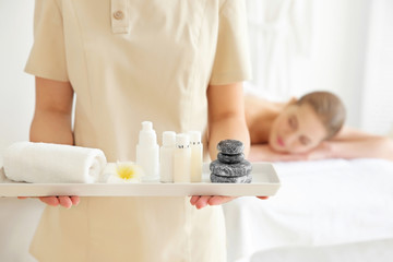 Obraz na płótnie Canvas Masseuse holding tray with cosmetics in the spa salon