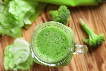 Mason jar with fresh vegetable smoothie on wooden table