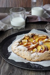 Homemade rustic galette with peaches. Gallette with a buttery crust and sweet fruit filling.