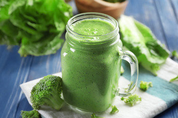 Mason jar with fresh vegetable smoothie on table