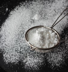 Sugar powder in sieve. Selective focus