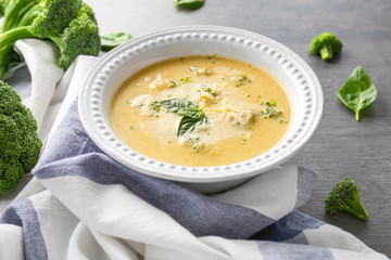 Broccoli cheddar soup in bowl on wooden kitchen table
