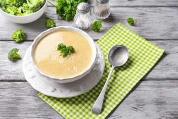 Broccoli cheddar soup in bowl on wooden kitchen table