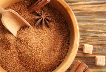 Bowl with sweet cinnamon sugar on wooden background, closeup