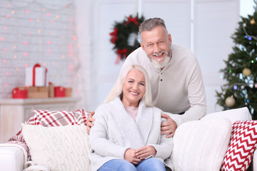 Happy senior couple resting at home on Christmas eve