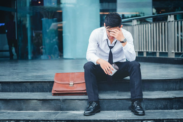 Unemployed Tired or stressed businessman sitting on the walkway after work Stressed businessman...