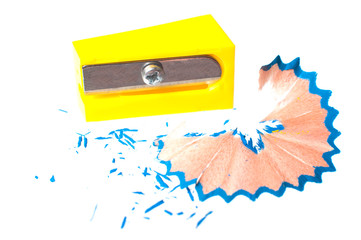 Yellow pencil sharpener and shavings from a pencil on a white background